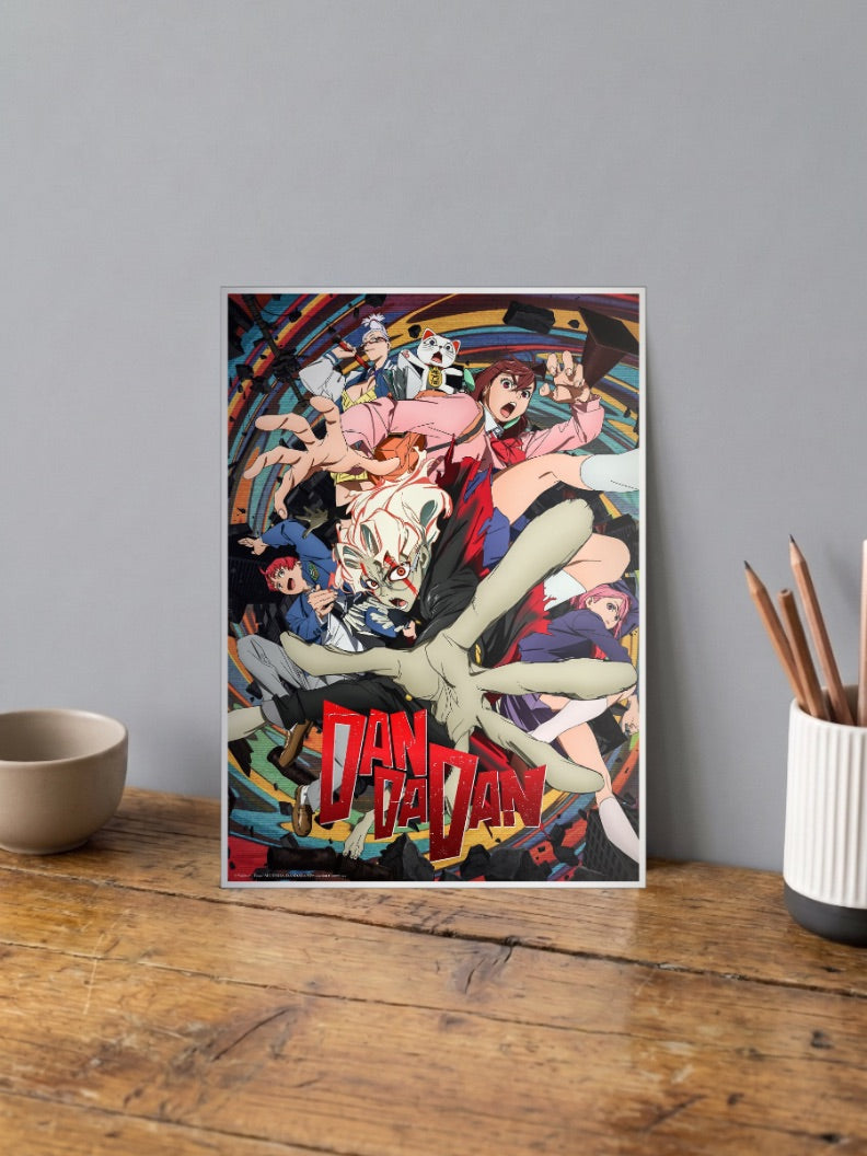 Dandadan Cast Reaching Out Anime Poster shown in A4 size on a wooden desk