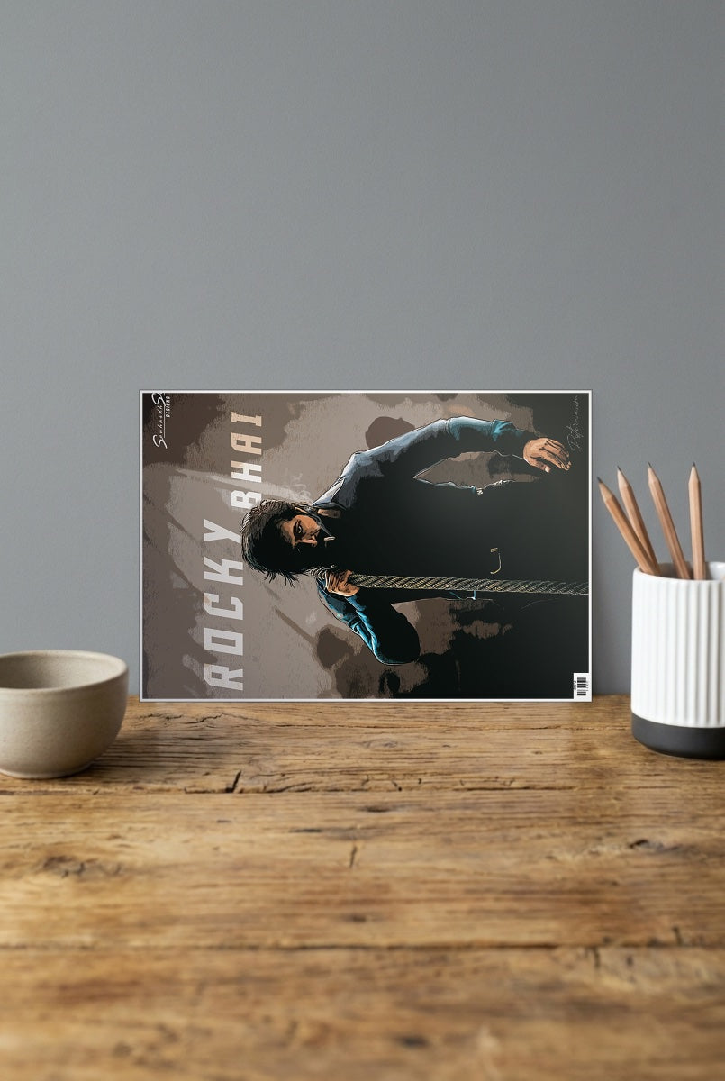 Kgf Rocky Bhai Sandalwood Movie Poster shown in A4 size on a wooden desk