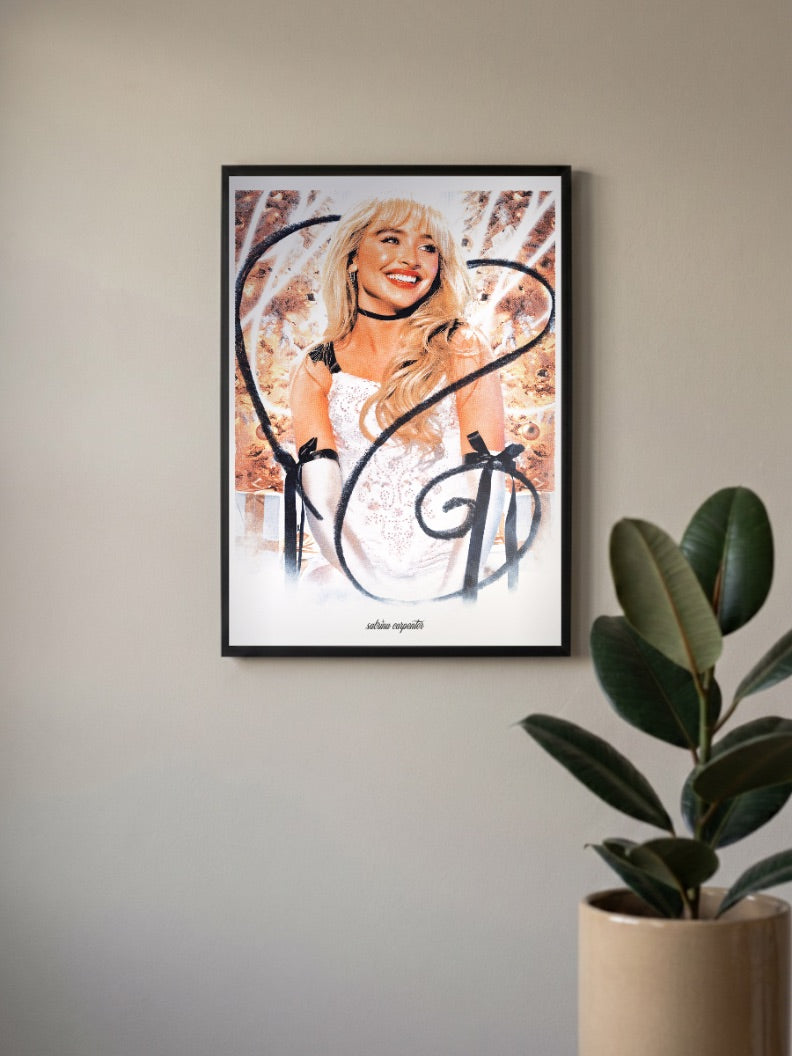 Sabrina Carpenter Glam Portrait Singers Poster in a black frame, mounted on a wall